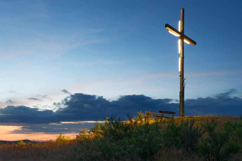 The illuminated summit cross on the Alte Grimme mountain near Elkeringhausen, evening light