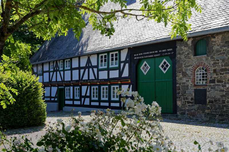 Historic farmhouse in Küstelberg, with roses in the foreground